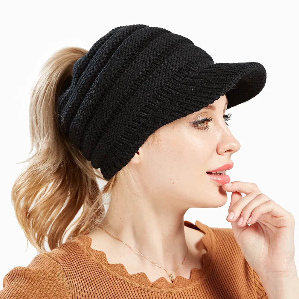 Women's acrylic knitted ponytail beanie hat in beige colour on a model.