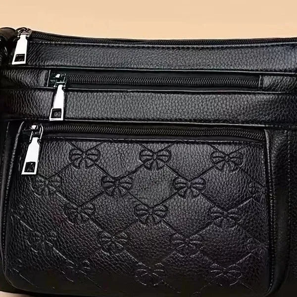 Women's black PU leather crossbody shoulder bag with embossed pattern and phone pocket