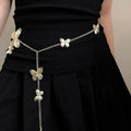 Gold and silver butterfly motif waist chain jewellery belt for women on a plain background.