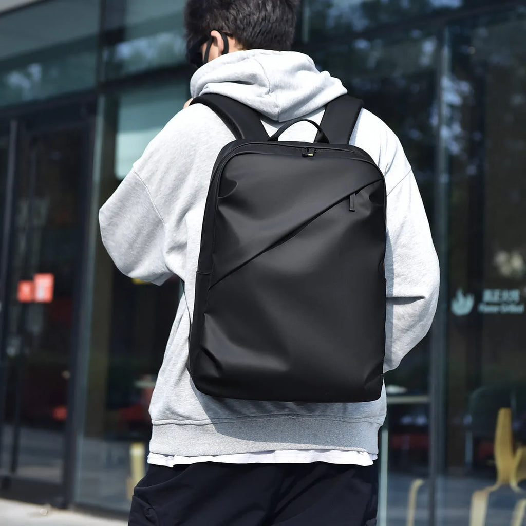 Waterproof PU leather backpack in black, blue or grey showing simple design and sewing thread detailing