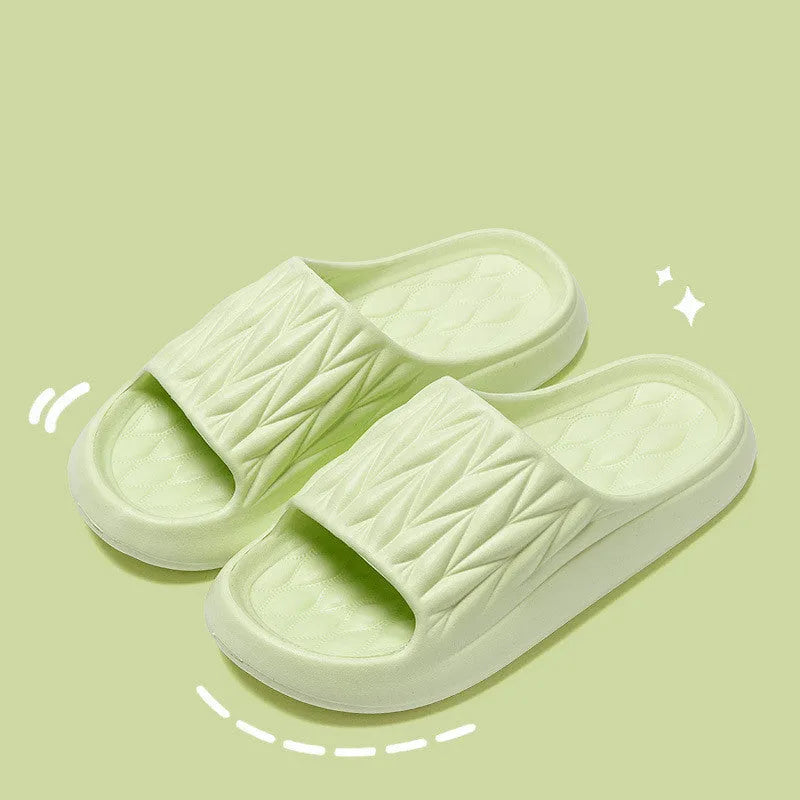 Pair of leaf-textured EVA indoor slippers on a solid background, showing non-slip sole.