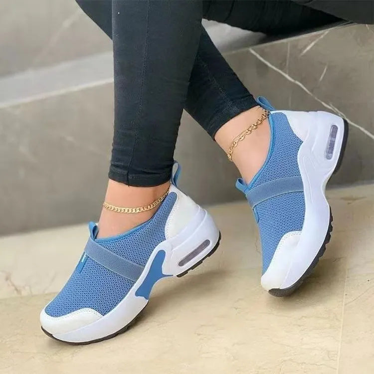 Women's flat mesh sneakers in light grey with white rubber soles and colour stitching.