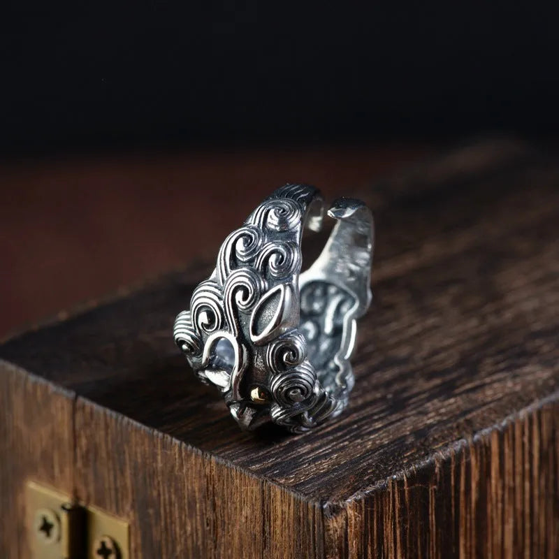 Silver open ring with detailed Jibeast zodiac animal pattern, shown on a hand.