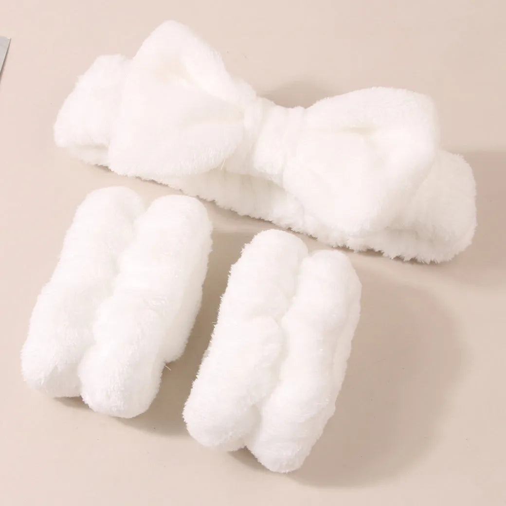 Keep dry facial brush set with plastic handle, coral fleece hair band, and stack of purple and pink face wash sponge suits.
