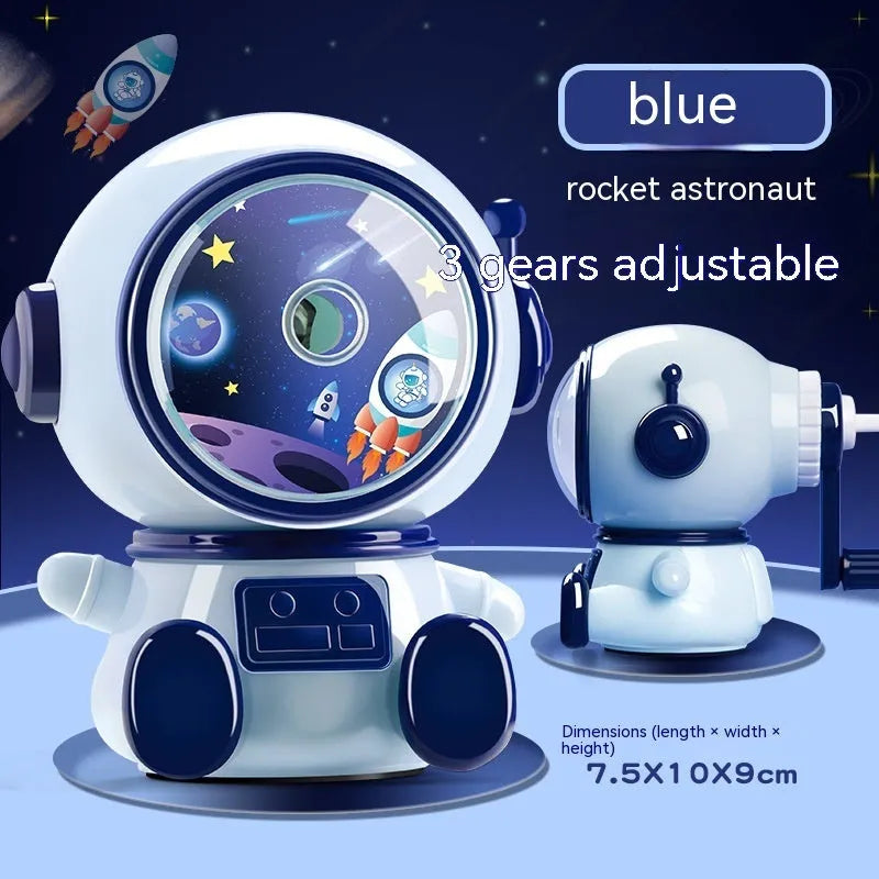 Blue and pink cartoon astronaut model manual pencil sharpener for children on a desk.
