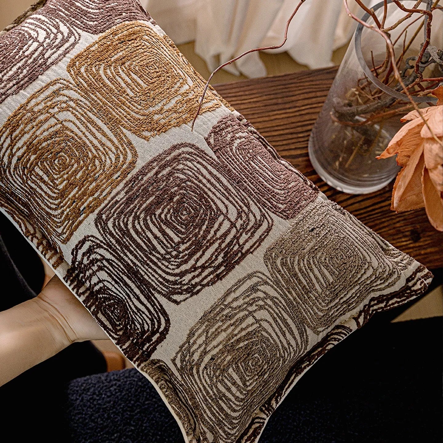 Cream and coffee-coloured abstract coil pattern on square and rectangular polyester pillow covers.
