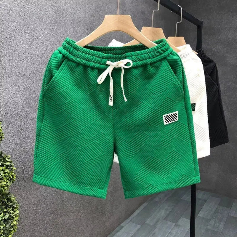 Men's solid colour polyester sports shorts with micro elasticity in white, black, or green.