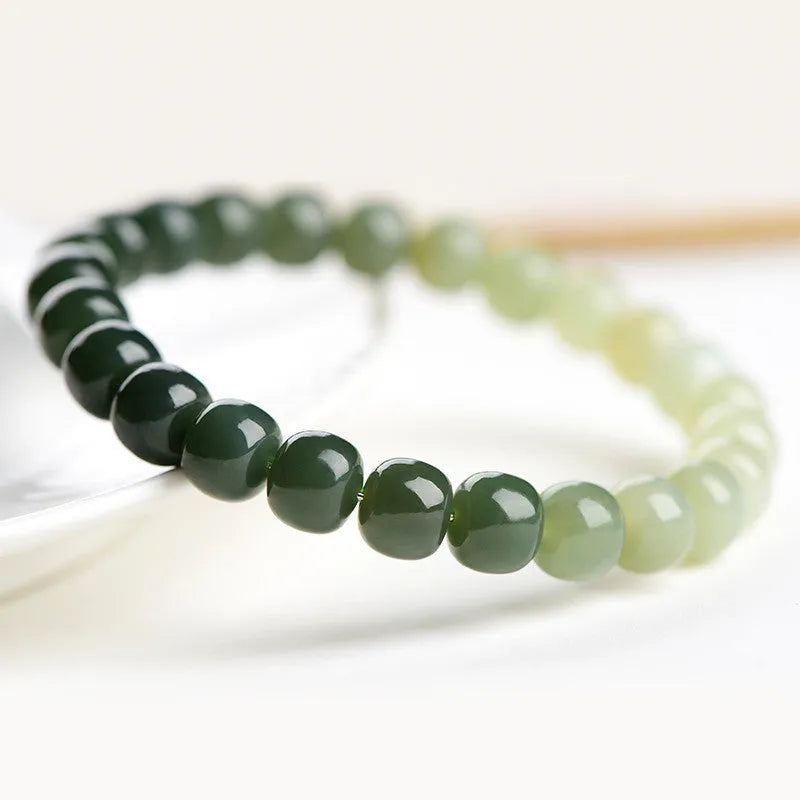 Natural Hetian jade bracelet with gradient clear water coloured beads on a wrist.