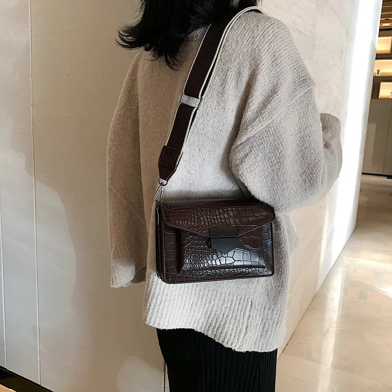 Vintage PU crossbody bag in black, shown with adjustable strap and open to reveal polyester lining.