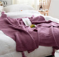 Nordic fringed knit ball acrylic blanket in beige colour on a sofa