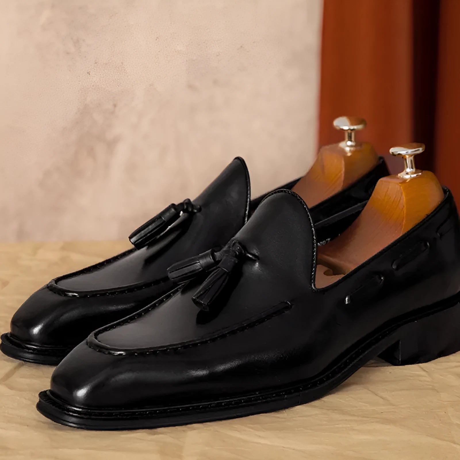 Men's brown leather loafers with fringed detail and slip-on design on rubber sole