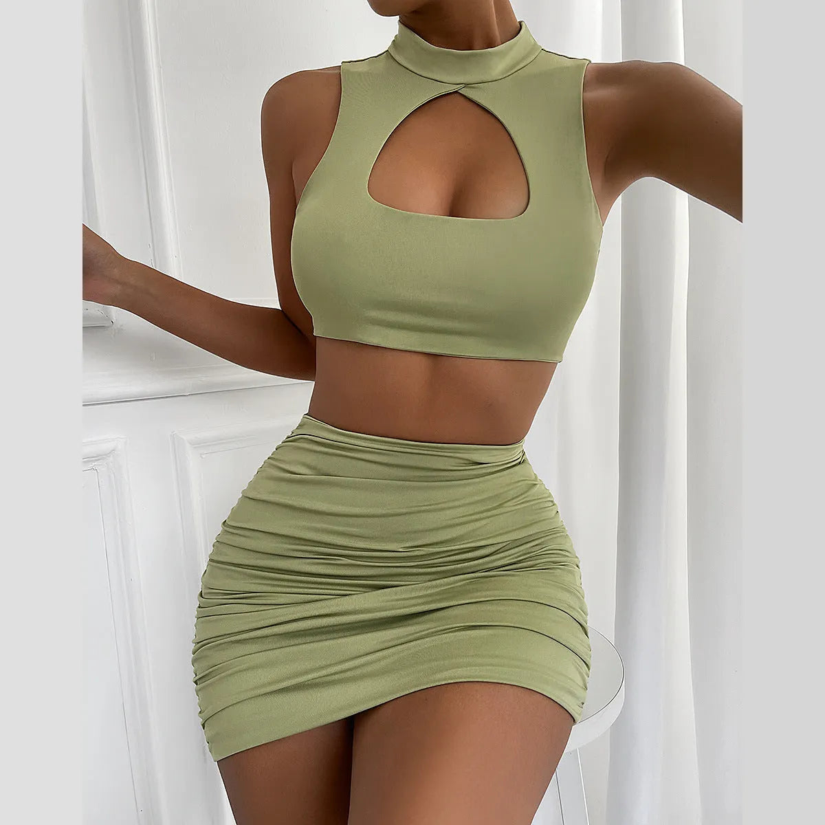 Light purple women's two-piece set with hollow-out vest top and split skirt on a model.
