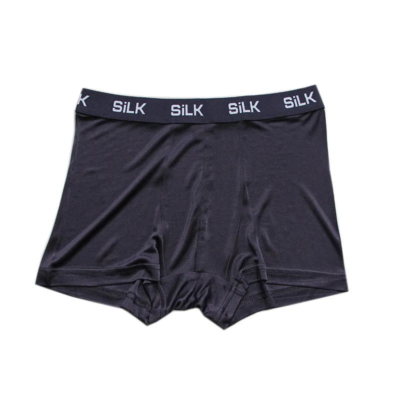 Man wearing loose-fit silk shorts in navy blue, showing casual style and breathable design.