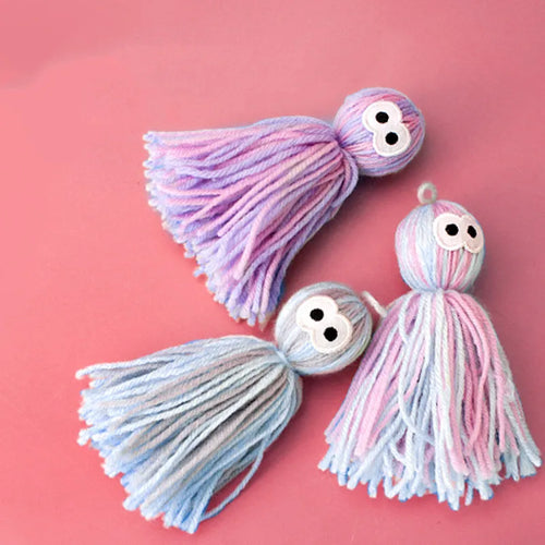 Blue grey wool cat toy with teaser stick hanging from furniture