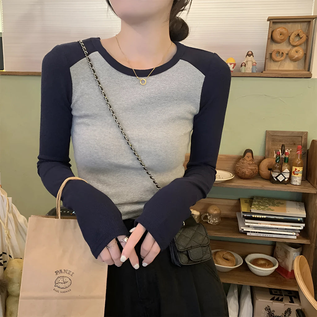 Women's dark blue viscose top with embroidery detail and long princess sleeves on a hanger.