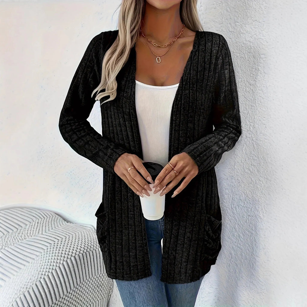 A grey loose fit long sleeve cardigan with pockets hanging on a hanger.