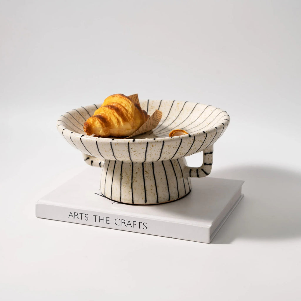 Black and white striped retro-style resin fruit or dessert plate on a table.