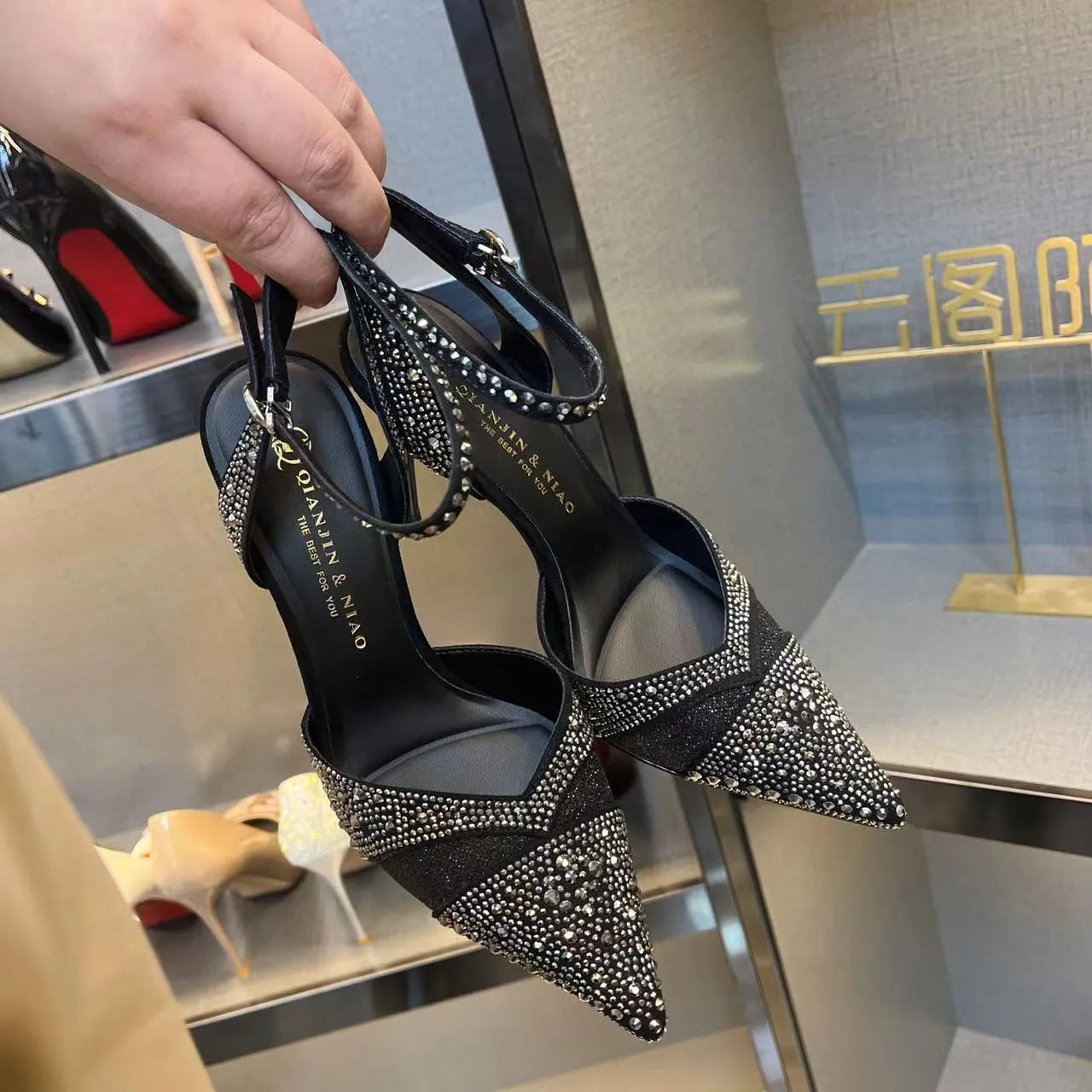 Women's silver and black hollow high heels with red sole and pointed toe design
