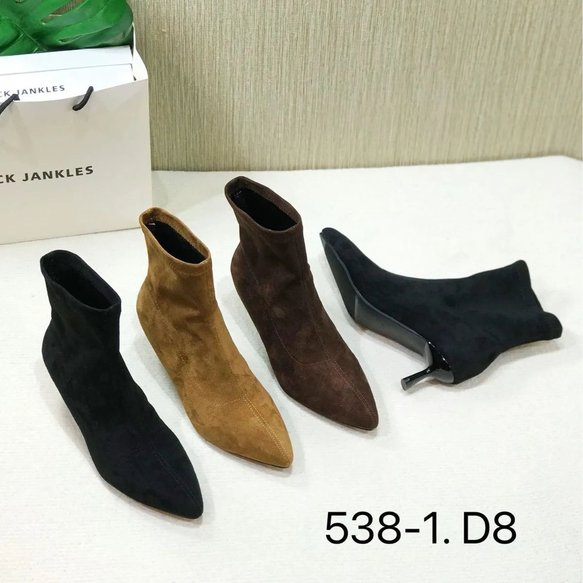 Black pointed toe ankle boots with a stiletto heel on a plain background.