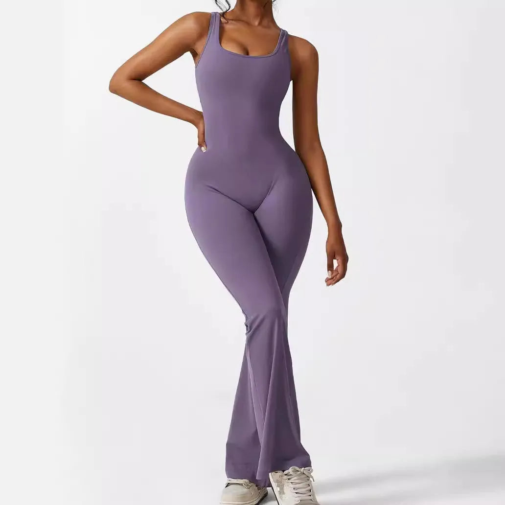 Woman wearing a sleeveless army green flare jumpsuit for yoga, showcasing the fashionable waist and trouser length.