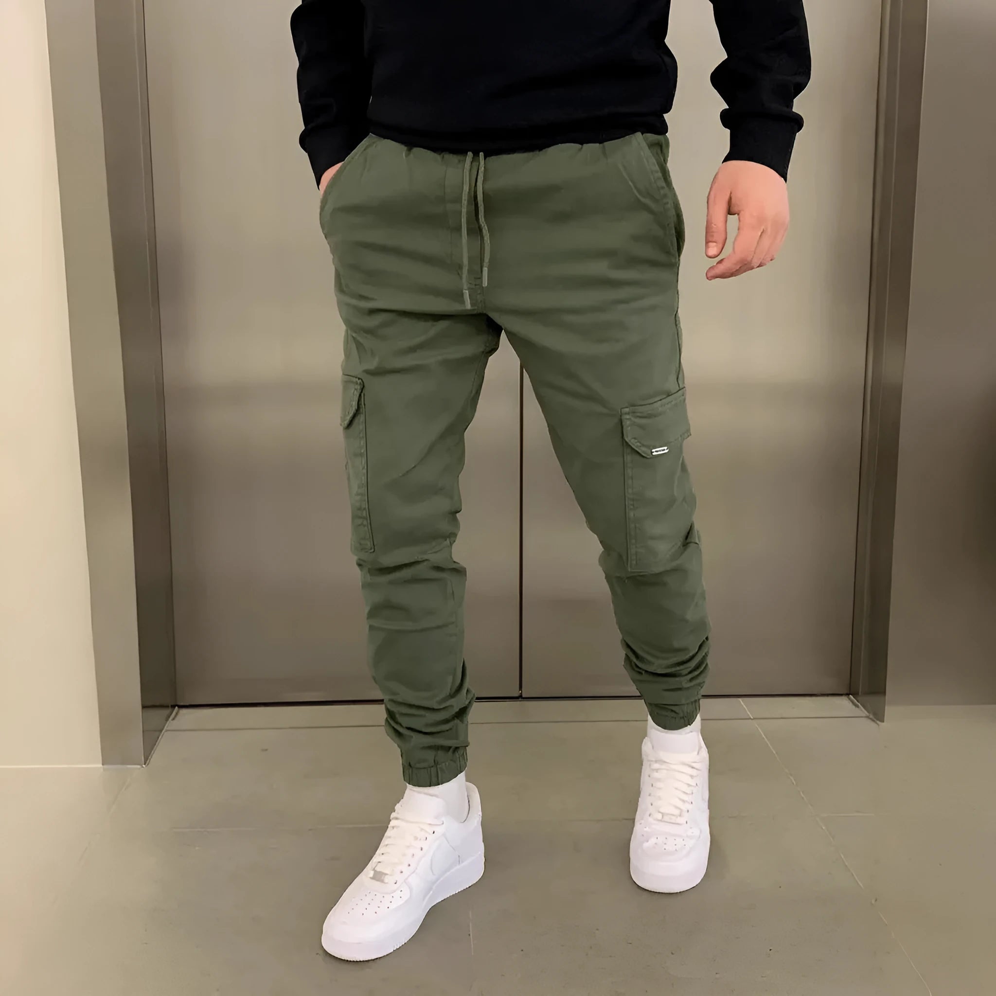 Men's loose-fit polyester casual trousers with elastic waistband and patch pockets in army green colour