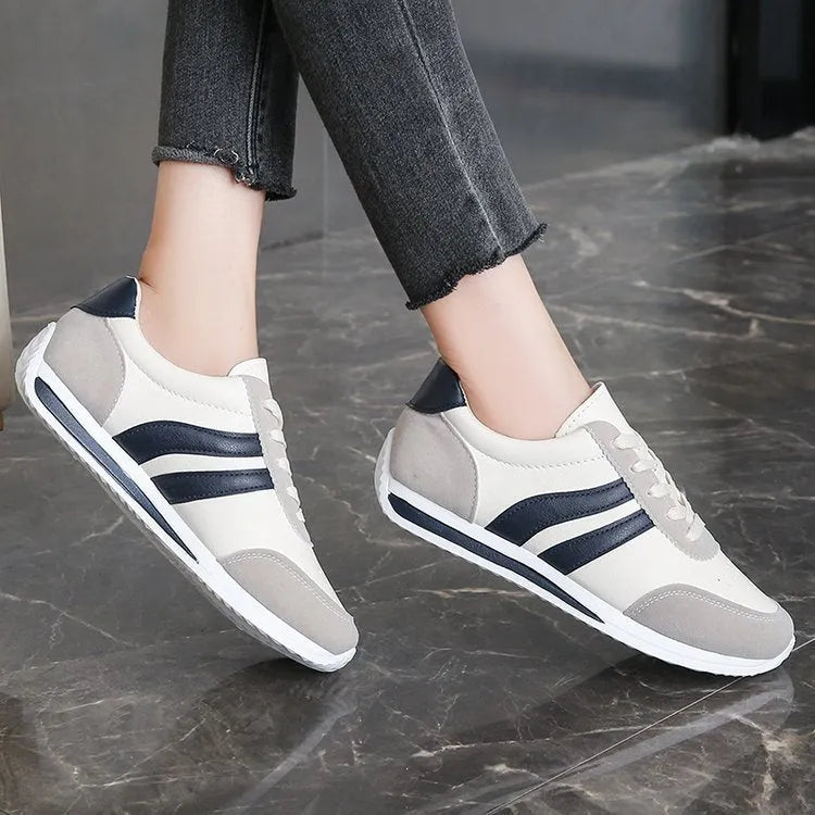 Red and blue lace-up running sneakers with soft rubber sole and mesh upper on white background