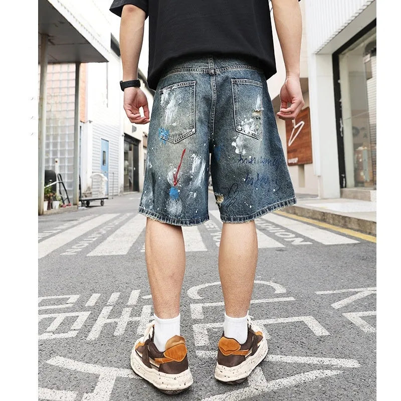 Blue ripped denim jeans shorts for men with graffiti design and straight leg opening.