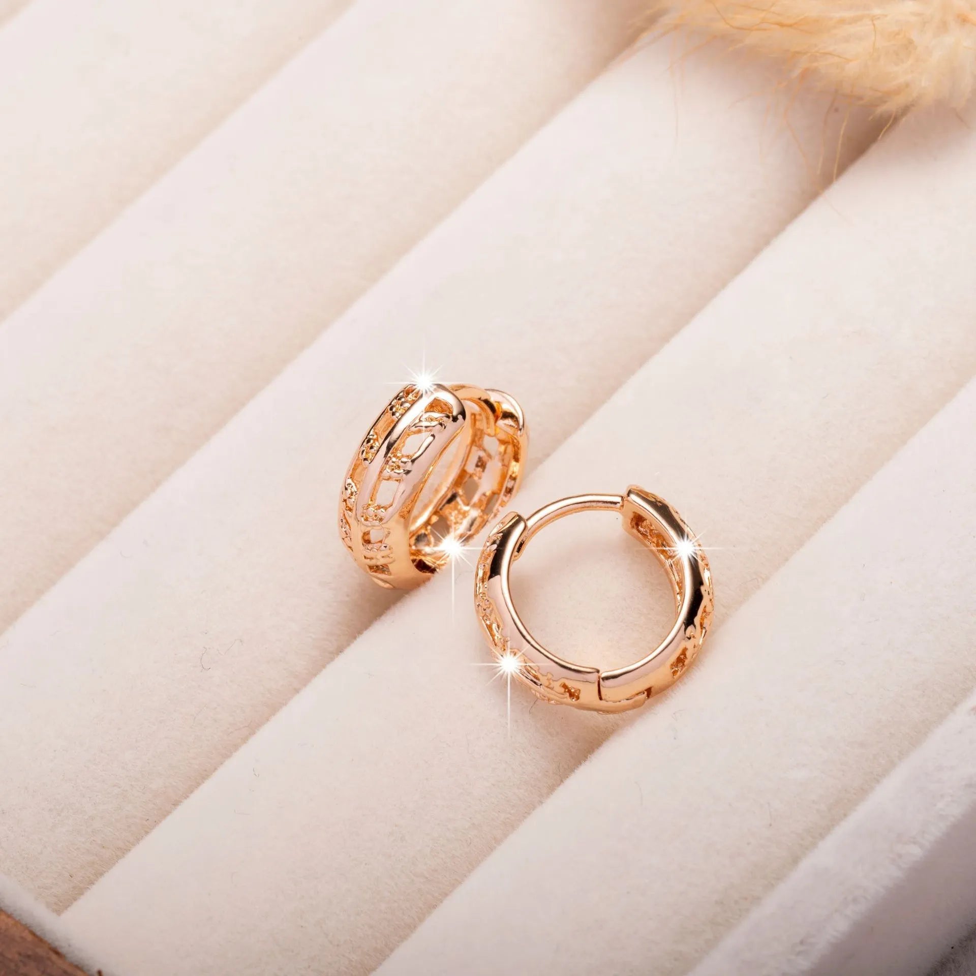 Small copper earrings with a hollowed-out heart-shaped leaf design in rose gold finish.