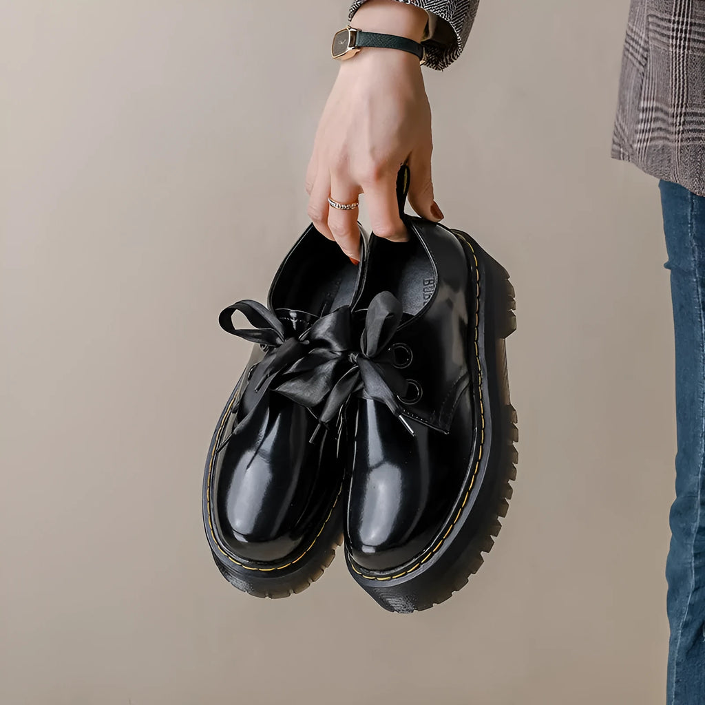 Women's thick soled leather shoes with ribbon cross straps and lace closure in black or white