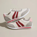 Red and blue lace-up running sneakers with soft rubber sole and mesh upper on white background