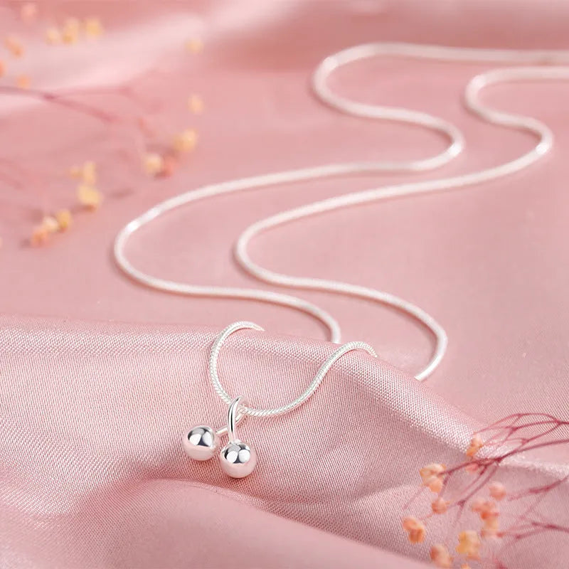 Silver cherry pendant necklace on an adjustable snake bones chain for women.