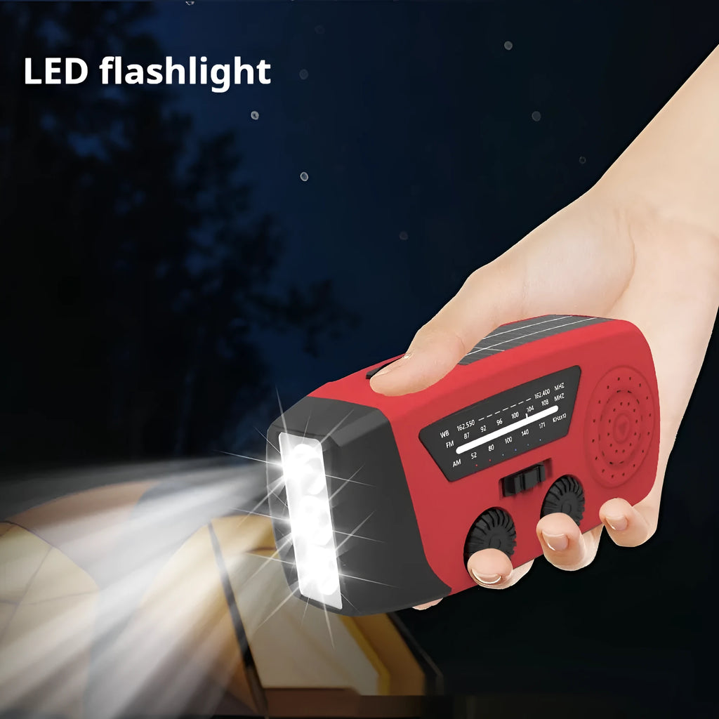 Red hand-crank emergency radio torch with solar panel, LED flashlight, and USB charging port.