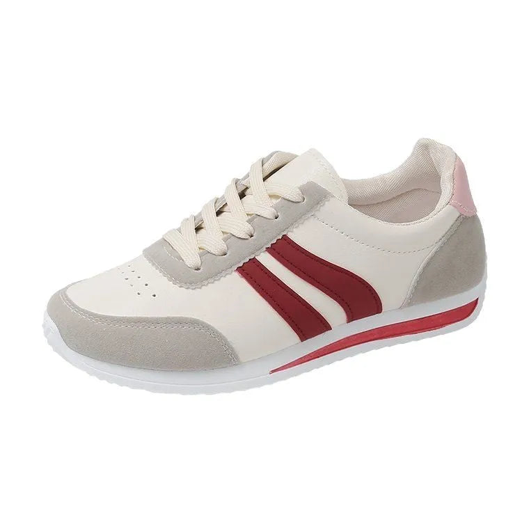 Red and blue lace-up running sneakers with soft rubber sole and mesh upper on white background