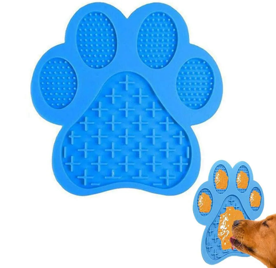 Blue silicone dog licking mat with bone texture and suction cups on the back, placed on a tiled wall.