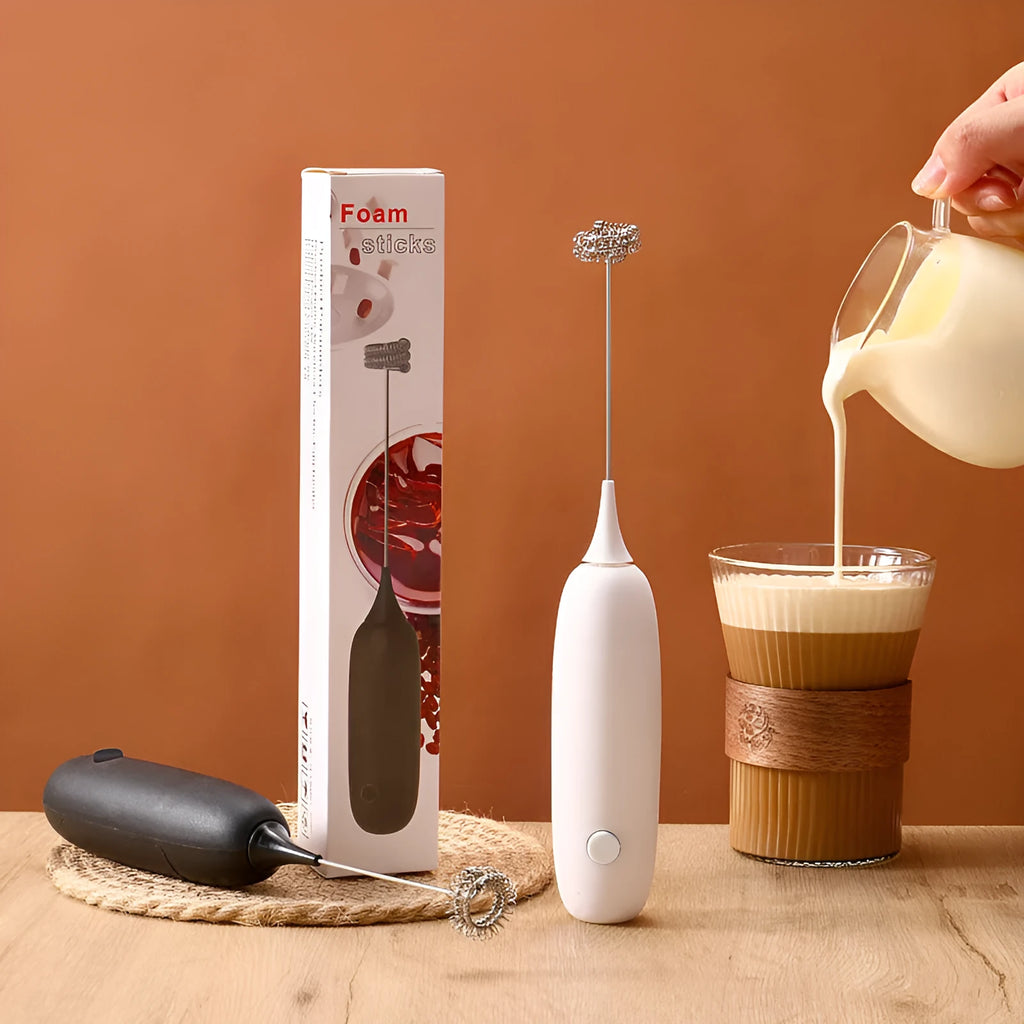 Black and white electric hand-held milk frother for coffee drinks