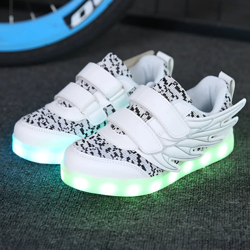 Children's plum red sneakers with multicolour LED lights glowing on the soles.
