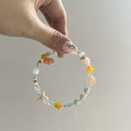 Orange summer bracelet with diamond-shaped alloy charm and round elements on mixed-material band