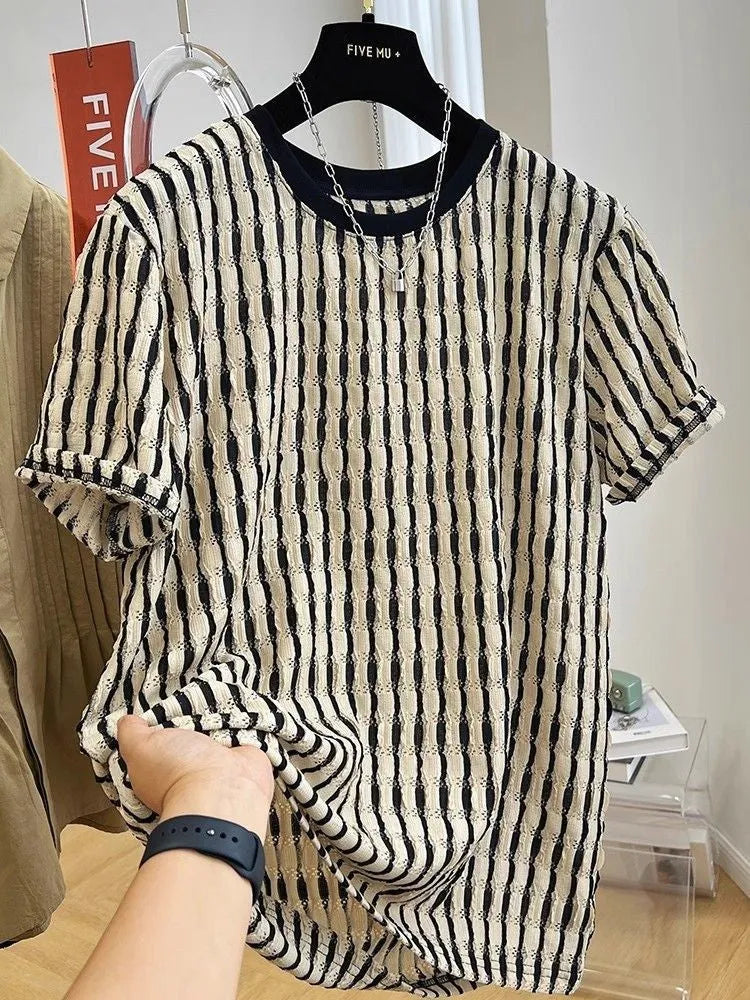 Man wearing a black and white striped loose casual short sleeve shirt made from linen and silk blend.