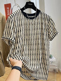 Man wearing a black and white striped loose casual short sleeve shirt made from linen and silk blend.