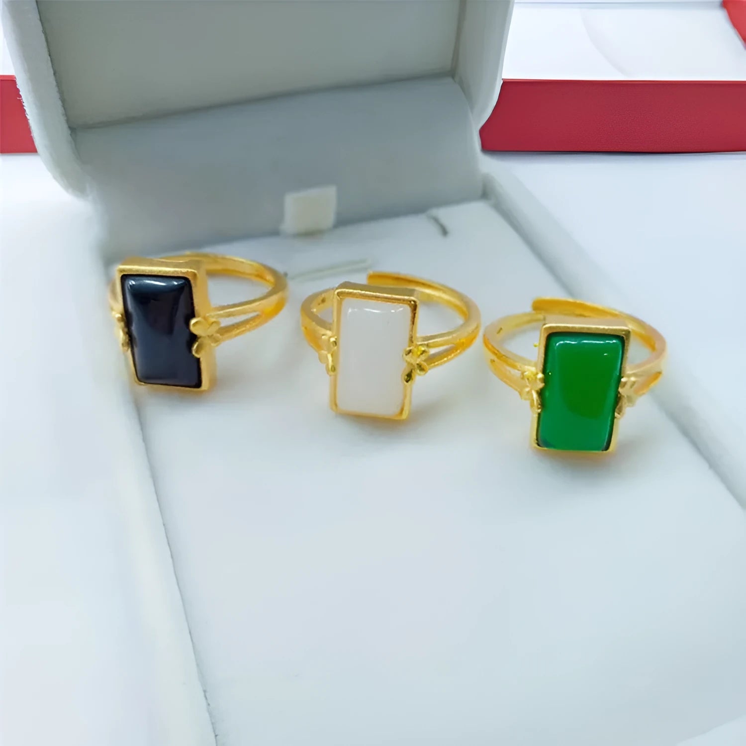 Adjustable gold-plated brass ring with a long coloured gemstone in green, white, or black.