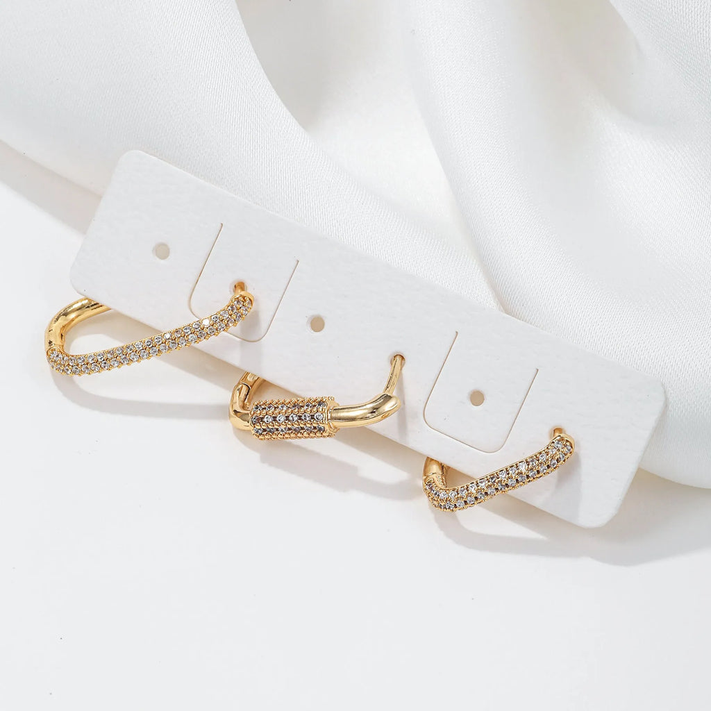 Three geometric copper earrings with zircon micro inlay in clip-on design showing ellipse and quadrilateral shapes
