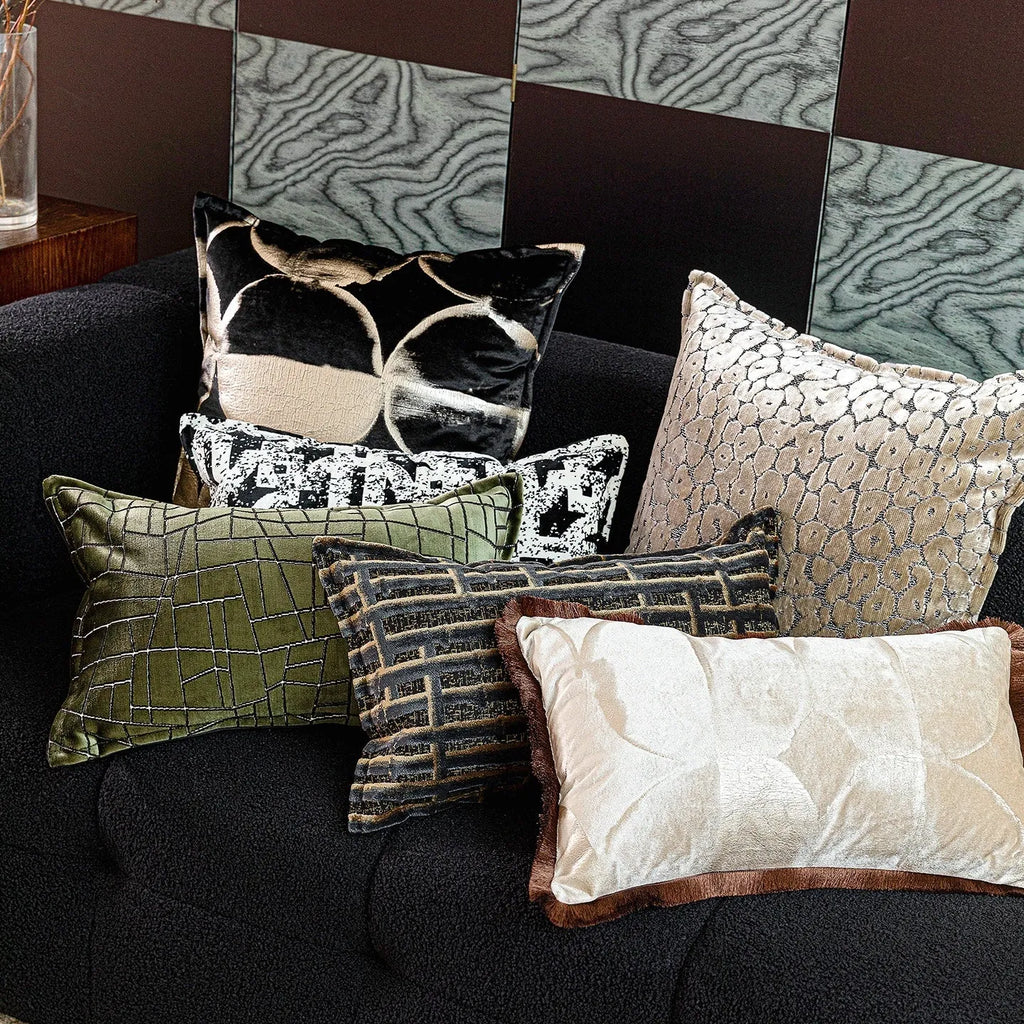 Black and gold abstract pattern flannel decorative cushion on a grey sofa.