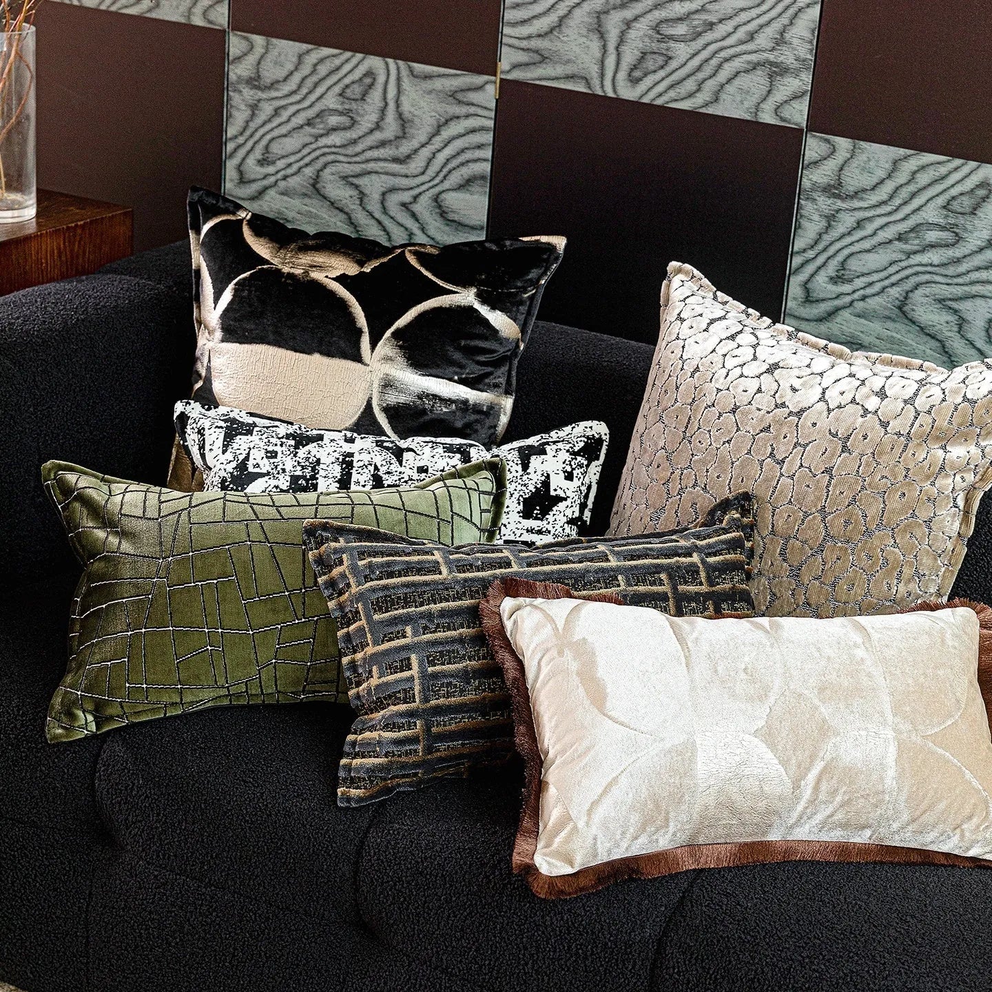 Black and gold abstract pattern flannel decorative cushion on a grey sofa.