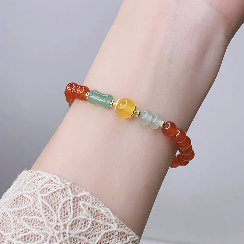 A red agate bracelet for women with Chinese style dragon and lucky bag motifs.