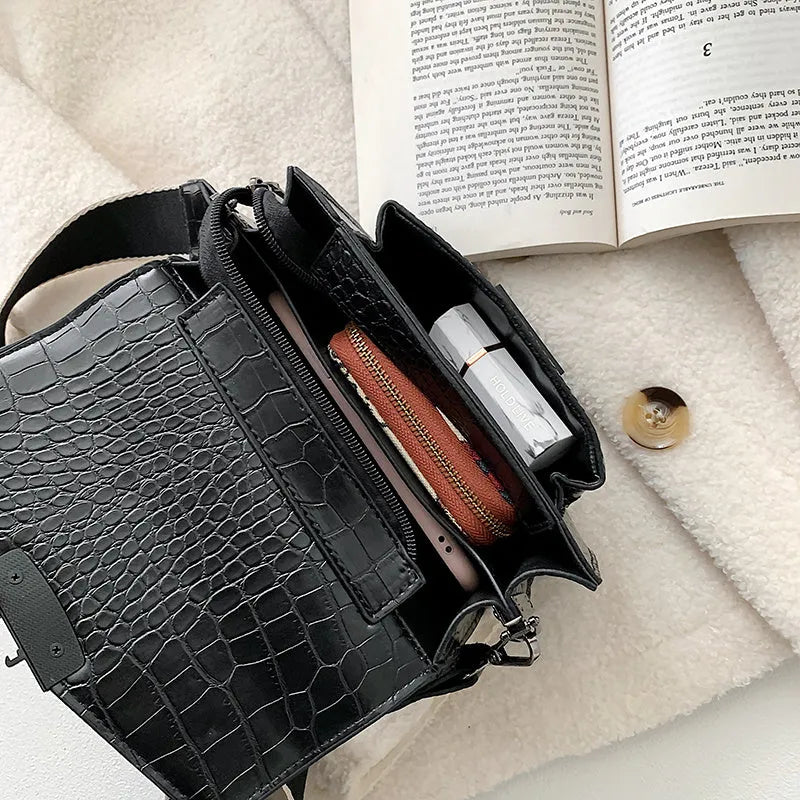 Vintage PU crossbody bag in black, shown with adjustable strap and open to reveal polyester lining.