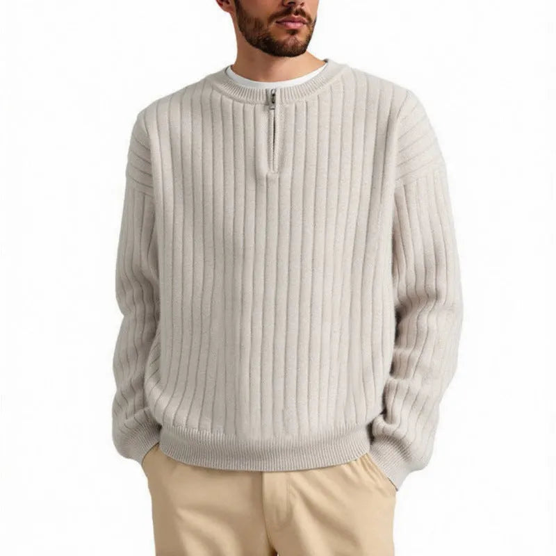 Man wearing a grey half-zip loose knit sweater, showing the textured fabric and front zip.