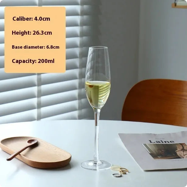 A single clear French goblet champagne glass on a table.