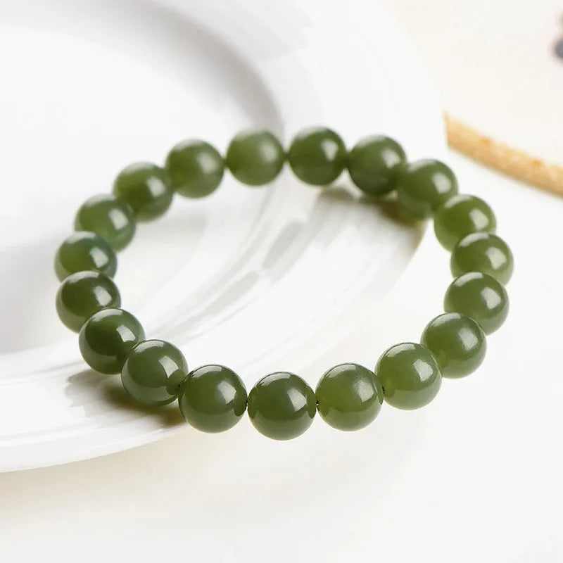 A polished Hetian jade bead bracelet in a light ice-clear colour, showing smooth round beads on a string.