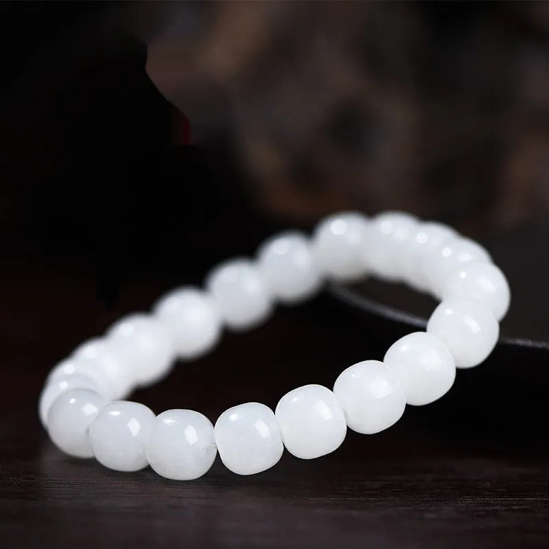 White Hetian jade barrel bead bracelet for men and women on a wrist, showing three bead size options.
