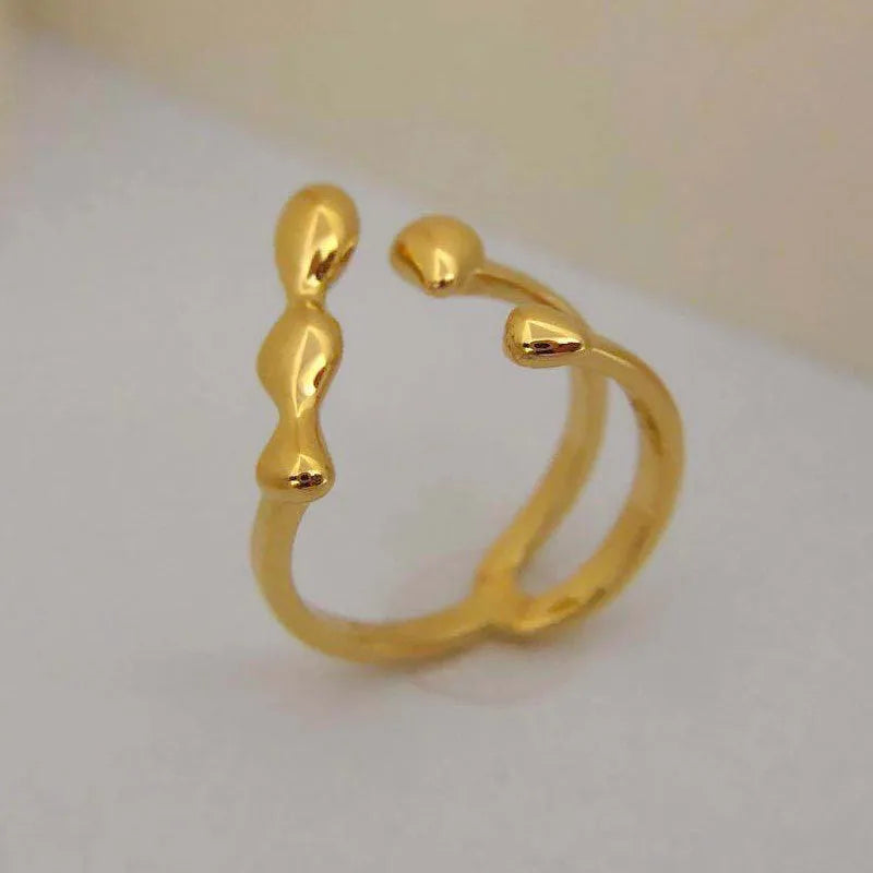 Brass opening ring with spherical design elements in gold finish